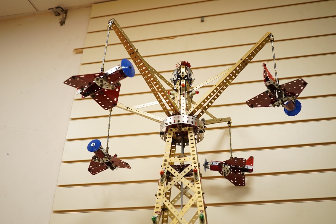 A Meccano model of a fairground ride, incorporating an electric motor in the base and lighting throughout, built in the style of a shop display centrepiece, approx 106cm high, 85cm diameter